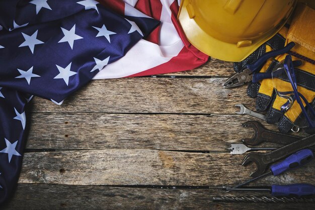 US-Flagge Set Bauwerkzeuge und Schutzhelm HolzhintergrundKonzept für den Tag der Arbeit am 1. Mai