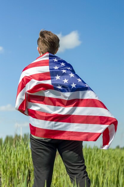 USA-Flagge, junger Mann hält die Flagge der Vereinigten Staaten von Amerika auf seinen Schultern, Foto ohne Gesicht