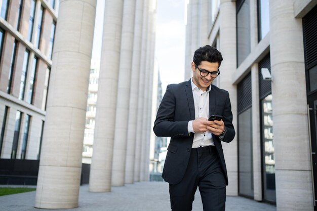 Usa un teléfono de un hombre de negocios, un hombre con traje de negocios va a trabajar a la oficina