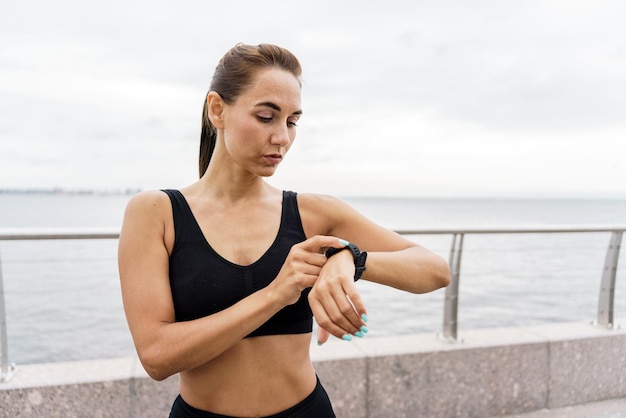Usa um relógio de fitness para uma pessoa forte e esportes para a saúde Atleta corredor em roupas de fitness