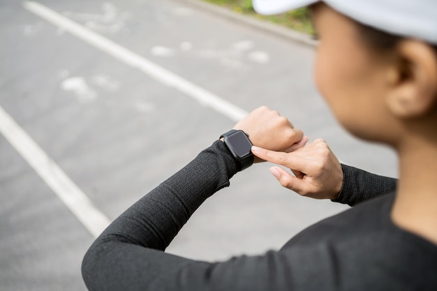 Usa um relógio rastreador de pulseira de fitness no braço, uma mulher esportiva faz um treino