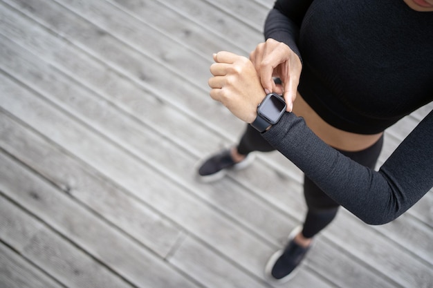 Foto usa um relógio rastreador de pulseira de fitness no braço, uma mulher esportiva faz um treino