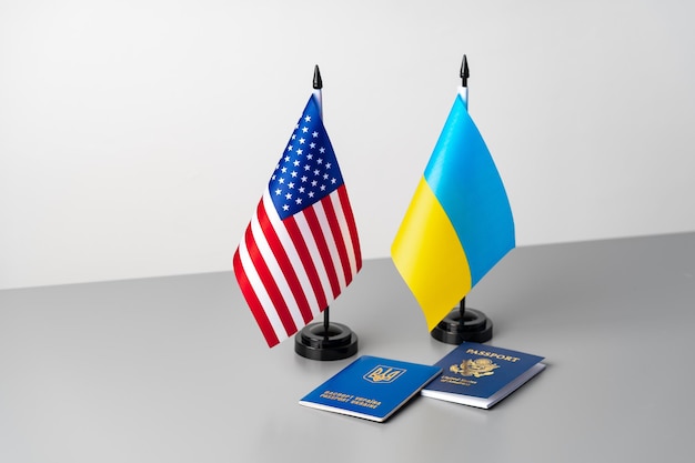 USA und Ukraine Fahnen mit Pässen auf grauem Tisch Tourismus und Auswanderung Konzept