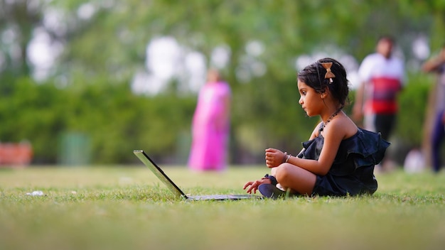 Usando laptop niña en la granja con buen humor