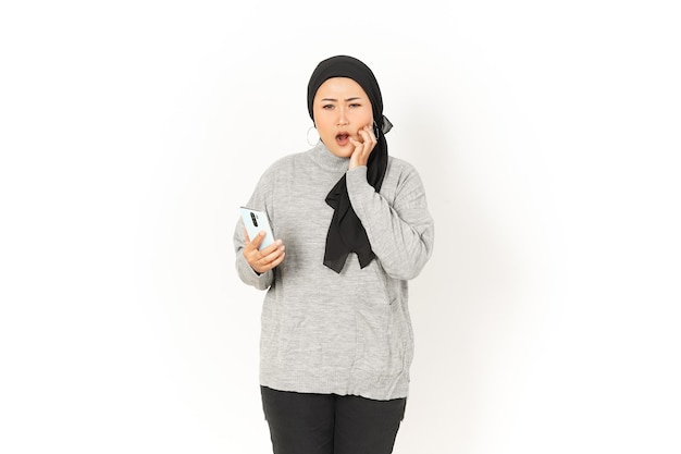 Usando o telefone e se preocupando com a bela mulher asiática usando um hijab isolado no fundo branco