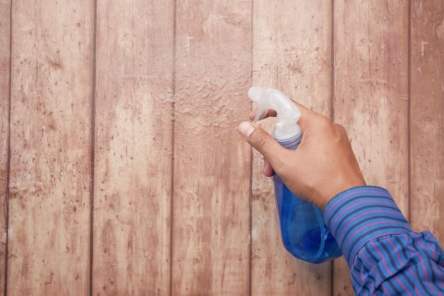 Usando spray desinfetante para limpar a superfície da mesa