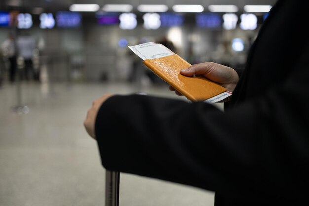 Usando el teléfono en el viaje mujer feliz viajando con pasaporte y equipaje caminando a la aerolínea
