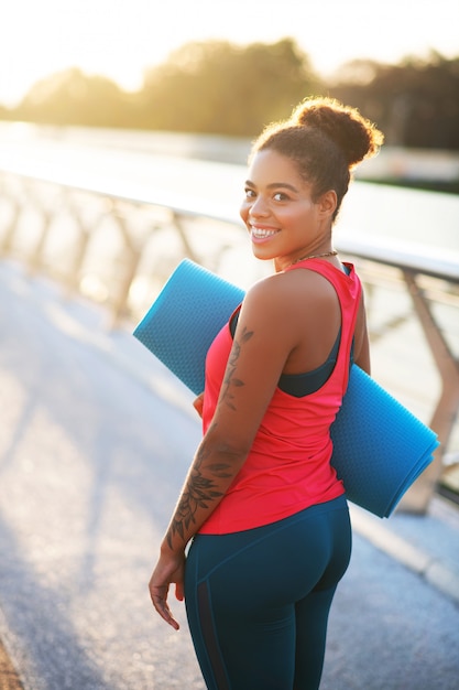 Usar ropa deportiva. mujer de piel oscura con ropa deportiva lista para  entrenar afuera en verano