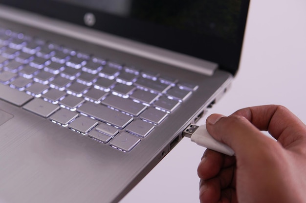 USB conectado a la computadora portátil para transferir datos con la mano