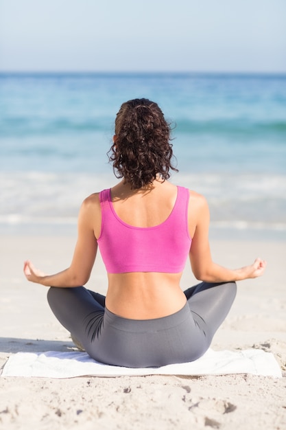 Use a vista da mulher em forma de yoga ao lado do mar