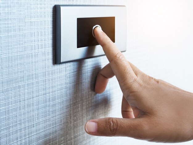 Use el dedo para presionar el botón en la pared frente a la puerta de la habitación.