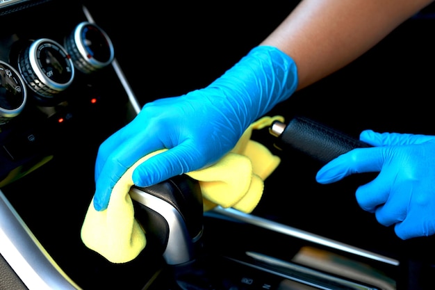 Foto use luvas e use um pano para limpar o interior do carro. limpe a área da engrenagem