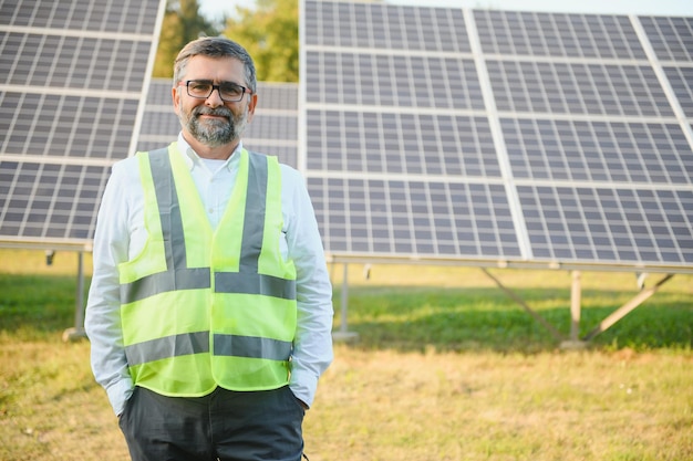 Usina solar Homem parado perto de painéis solares Energia renovável