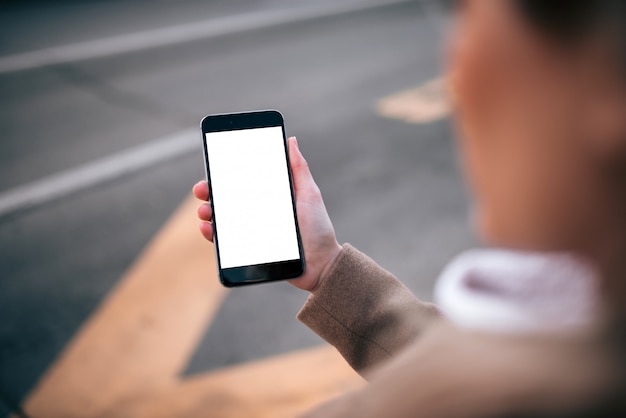 Uso de la aplicación de servicio de taxi en el teléfono inteligente, pantalla en blanco.