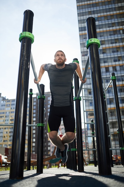 Foto uso de barras de dominadas al aire libre para entrenar