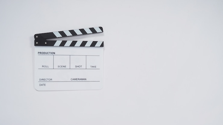 Foto uso de claqueta o pizarra de películas en la producción de video, el cine y la industria del cine. es de color blanco sobre papel.
