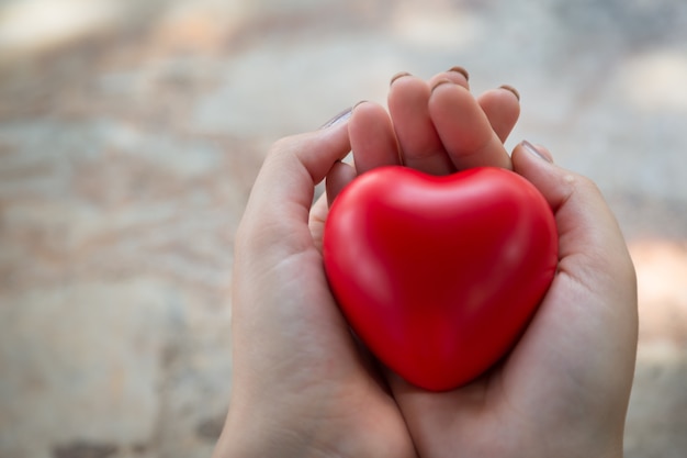 Foto uso del corazón rojo del asimiento de la mujer para el fondo