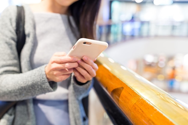 Uso da mulher do telefone celular no shopping