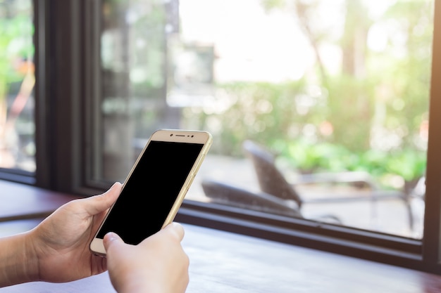 uso femenino teléfonos celulares imágenes borrosas en la cafetería como el fondo.