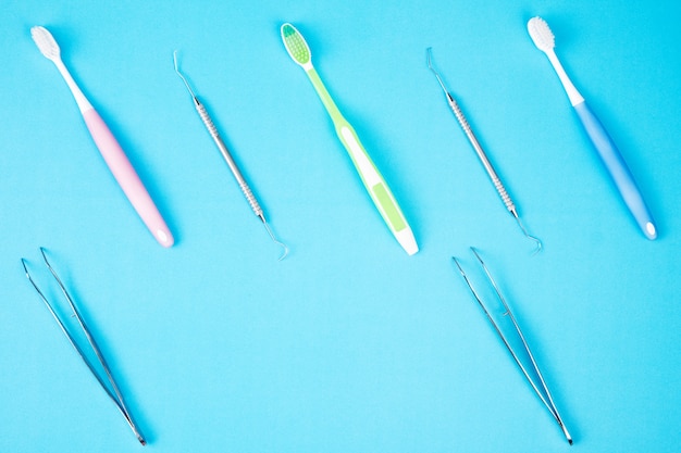 Uso de herramientas dentales para dentista sobre fondo azul.