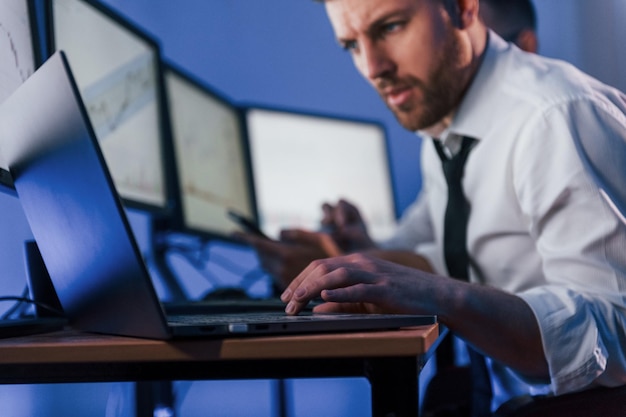 Uso de tecnología moderna para obtener ganancias Dos comerciantes de acciones que trabajan en la oficina con tecnología de intercambio