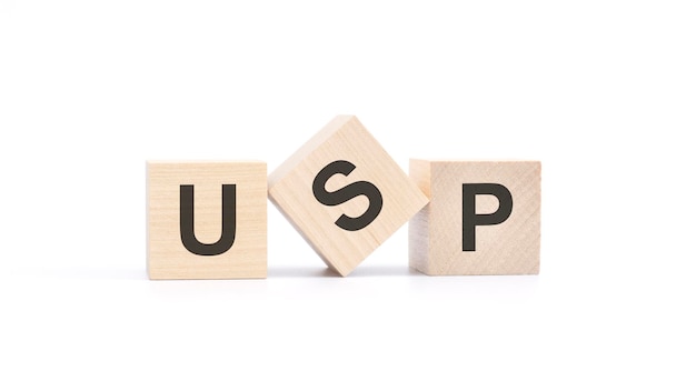 USP Akronym aus Holzblöcken mit Buchstaben Social Media Optimierungskonzept Draufsicht auf weißem Hintergrund