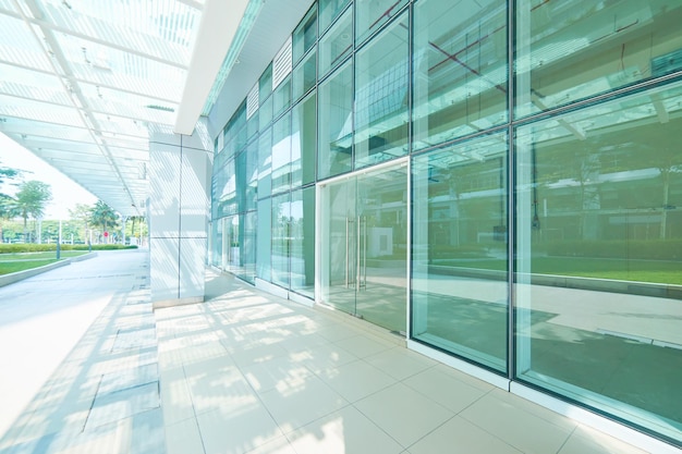 Äußeres eines modernen Bürogebäudes aus Stahl und grünem Glas mit leerem Gehweg. Panorama- und Perspektivansicht. modernes Architektendesign.