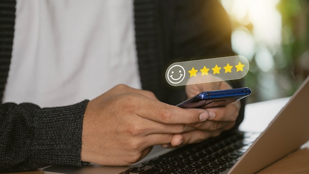 El usuario da una calificación de cinco estrellas utilizando un teléfono inteligente en la aplicación en línea para la satisfacción del cliente revisión opinión encuesta idea los usuarios califican su experiencia de servicio