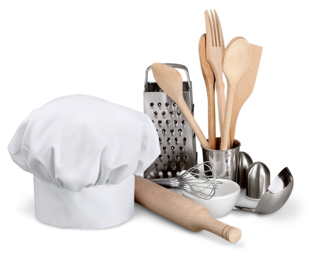 Utensílio de cozinha com chapéu de cozinheiro isolado no branco