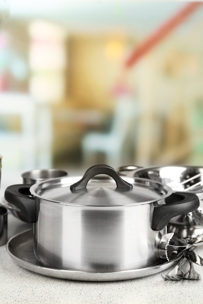 Foto utensilios de cocina de acero inoxidable en la mesa, sobre fondo claro