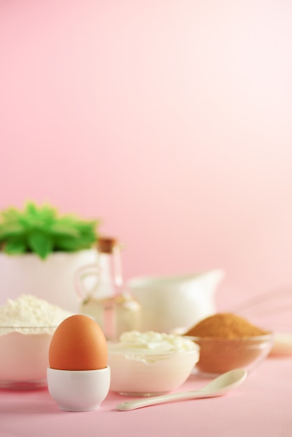 Utensilios de cocina blancos sobre fondo rosa.