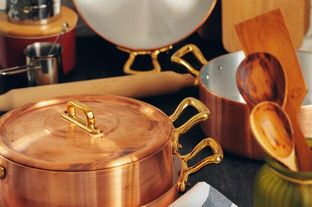 Utensilios de cocina de cobre con utensilios de cocina de madera de cerca
