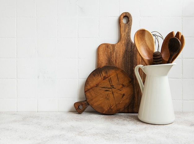 Utensilios de cocina, herramientas y vajilla en la pared de azulejos blancos de fondo. Interior, espacio de cocina moderno en colores brillantes. Espacio en blanco para un texto, vista frontal