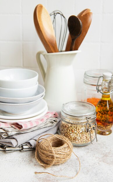 Utensilios de cocina, herramientas y vajilla en la pared de azulejos blancos de fondo. Interior, espacio de cocina moderno en colores brillantes. Espacio en blanco para un texto, vista frontal