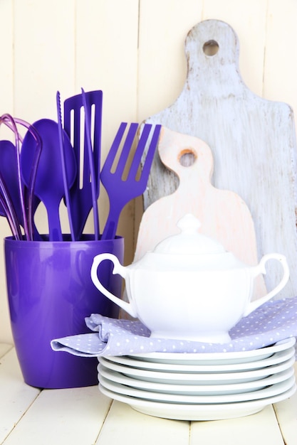 Foto utensilios de cocina de plástico en taza sobre mesa de madera