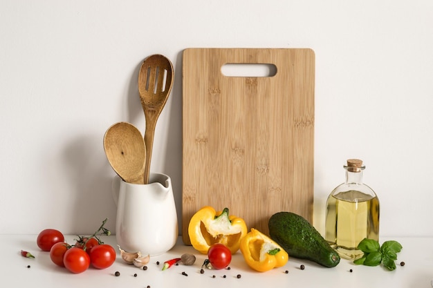 Utensilios de cocina, verduras y especias en el fondo de la pared de la mesa. Maqueta de plantilla de receta.