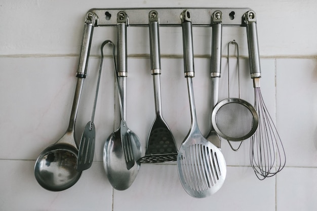 Los utensilios colgados en el gancho contra la pared en la cocina