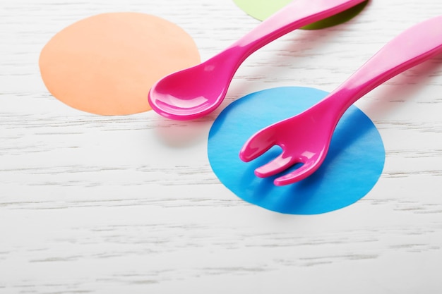 Foto utensilios de comida coloridos para bebés en una mesa de madera