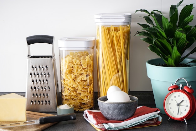 Utensílios de cozinha com produtos na parede da cozinha. Fechar-se.