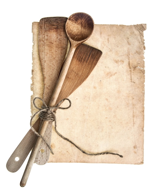 Utensílios de cozinha de madeira vintage e página de livro de receitas antigo, isolado no fundo branco. conceito de receitas da vovó