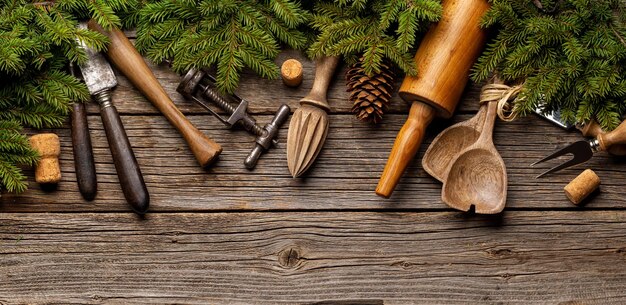 Utensílios de cozinha e galhos de árvores de abeto na mesa de cozinha Conceito de culinária de Natal