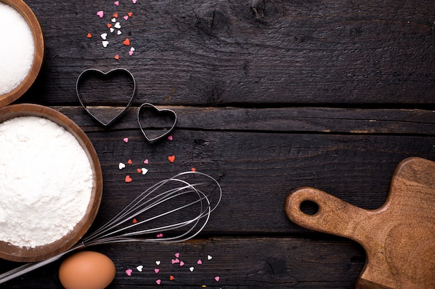 Utensílios de cozinha, farinha e açúcar na madeira