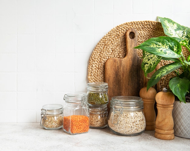 Utensílios de cozinha, ferramentas e louças na parede de azulejos brancos de fundo. Cozinha moderna e interior com cores brilhantes. Espaço em branco para um texto, vista frontal