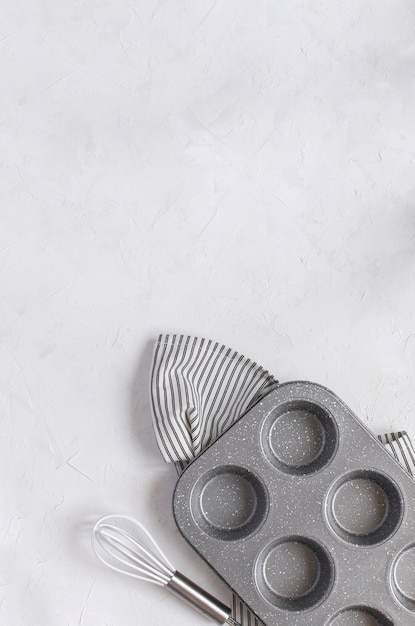 Utensílios de cozinha para assar - molde de metal Cupcake Bata no guardanapo listrado amassado.