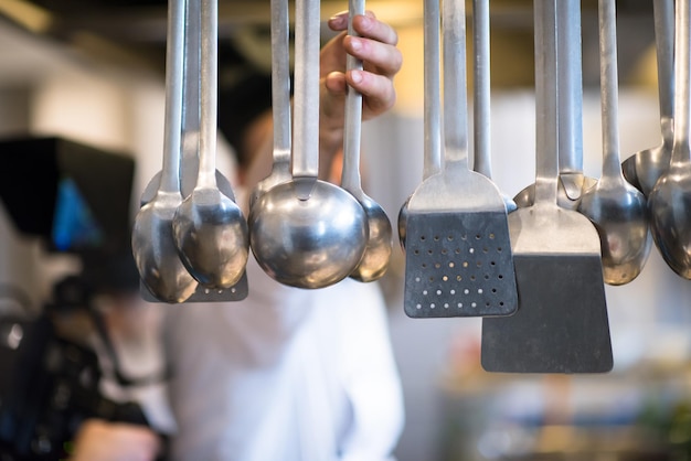 Utensílios de cozinha profissionais pendurados na cozinha de um restaurante