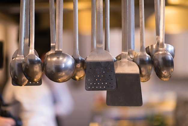 Utensílios de cozinha profissionais pendurados na cozinha de um restaurante