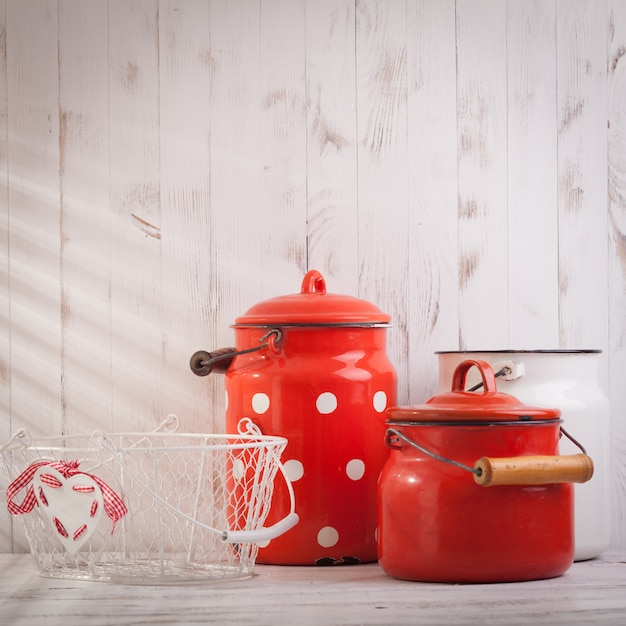 Utensílios de cozinha vintage vermelhos e brancos em uma talha branca