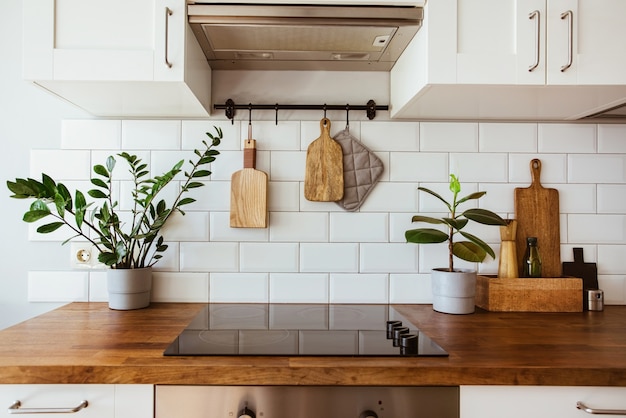 Utensílios de latão de cozinha acessórios de chef pendurados cozinha com parede de azulejos brancos e mesa de madeira ...