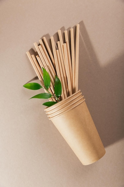 Utensílios de mesa de papel descartáveis Copos e canudos em fundo bege Conceito sem plástico e sem desperdício