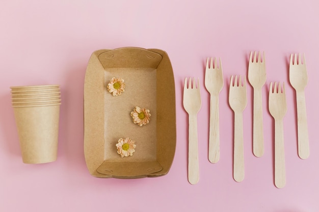 Utensílios de mesa descartáveis de papel no fundo rosa